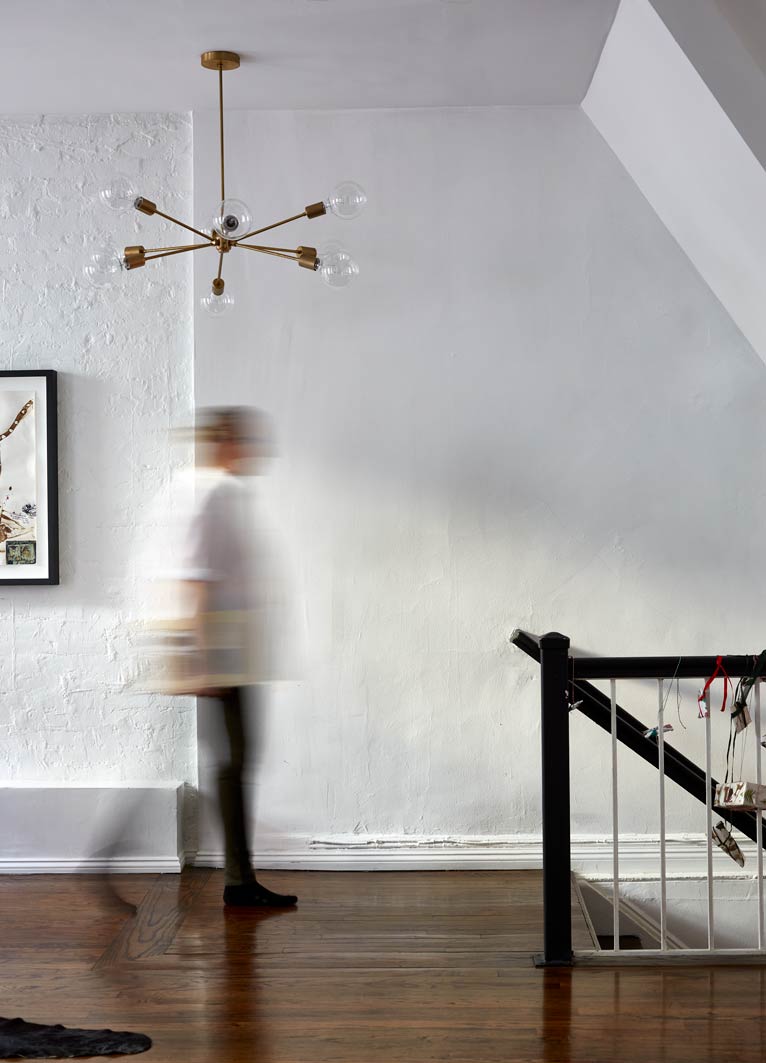 cocoon boto Personal walking beneath hanging light at top of staircase and walnut wood floors cocoon boto Personal walking beneath hanging light at top of staircase and walnut wood floors