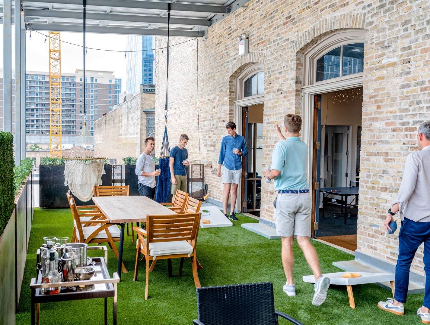 rooftop baby shower guests playing cornhole