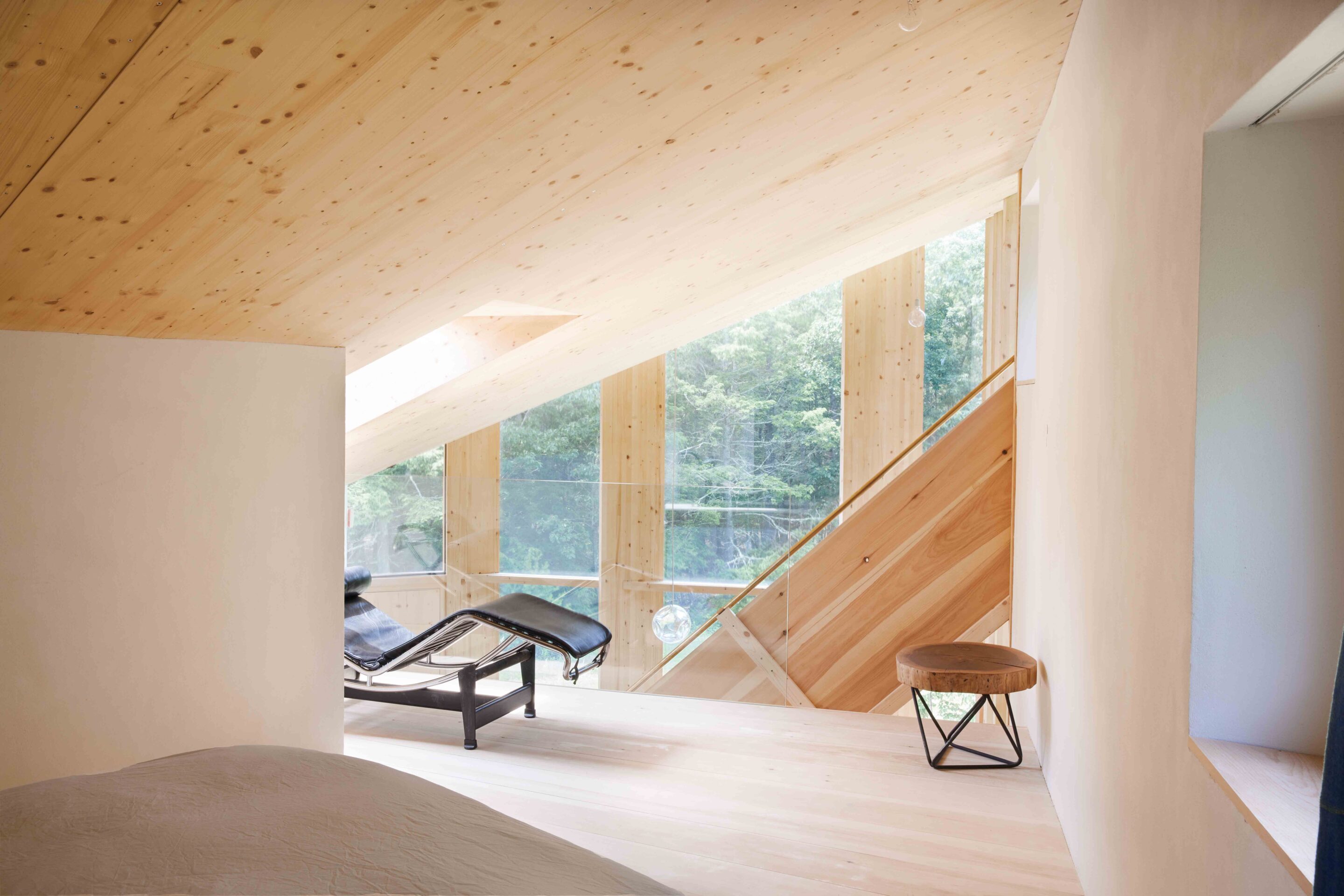 13 Casa Cometa Space Rental Interior Guest Bedroom Loft Suite facing windows with vintage le corbusier LC4 lounge chair and wooden side table